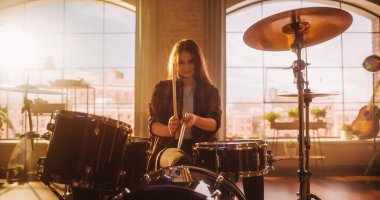 Expressive Drummer Girl Playing Drums in a Loft Music Rehearsal Studio Filled with Light. Rock Band Music Artist Learning a New Drum Solo. Talented