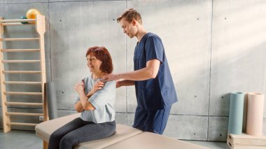 Advanced Sport Physiotherapy Specialist Stretching and Working on Specific Muscle Groups or Joints with Elderly Woman. MIddle Aged Female Treating Her