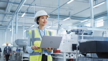 Portrait of a Happy Asian Female Engineer in Hard Hat Standing and Using Laptop Computer at Electronic Manufacturing Factory. Technician Thinking