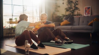 Smiling Elderly Couple Doing Core Strengthening Exercises Together at Home in Beautiful Living Room. Senior Man and Woman Motivate Each Other to be