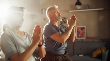 Close Up Portrait of a Senior Couple Doing Gymnastics and Yoga Stretching Exercises Together at Home on Sunny Morning. Concept of Healthy Lifestyle