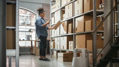 Warehouse Inventory Manager Using Smartphone to Scan a Barcode on Parcel, Preparing a Small Cardboard Box for Postage. Black Multiethnic Small