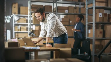 Successful Small Business Owner of a Retail Online Shop Preparing a Small Cardboard Parcel for Postage. Stylish Young Inventory Manager Working on