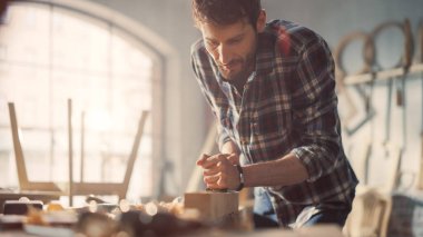 Dama Gömlekli Yetenekli Genç Sanatçı Tahta Çubuğu Şekillendirmek İçin El Uçağı Kullanıyor. Çekici Marangoz sonuçlardan memnun. Çalışan Adam