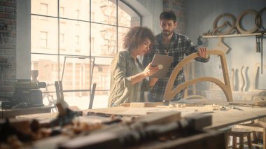 Tablet Bilgisayar Kullanan ve Mobilya Atölyesindeki Yeni Ahşap Sandalyenin Tasarımı Hakkında Konuşan İki Yetenekli Küçük İşletme Sahibi. Marangoz ve...