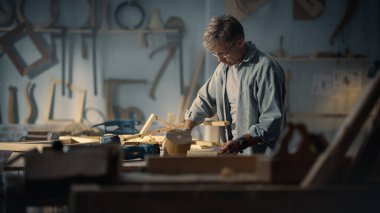 Bir Zanaatkar Mobilya Tasarımcısı 'nın Portresi Okurken ve Tahta Sandalyenin Bacaklarını Birleştirmeye Başlarken. Stüdyoda çalışan şık marangoz