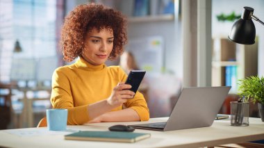 Güzel Ortadoğu Yöneticisi Yaratıcı Ofis Masasında, Akıllı Telefon 'u kullanarak oturuyor. Genç Tarz Kadını Gönderme İletisi, İnternet Taraması