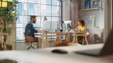 Şehir merkezi manzaralı ve bilgisayarla ilgili raporlarla çalışan iki uzman büyük pencerenin yanında oturuyor. Çeşitli Erkek ve Heyecanlı Kadın