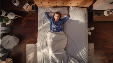 Top View Apartmanı: Güzel Genç Kadın Yatağında Cazibeli Uyuyor, Akıllı Telefon Alarm Saatini Kapatıyor, Kameraya Bakarak Yeni Bir Gün Kutluyor ve