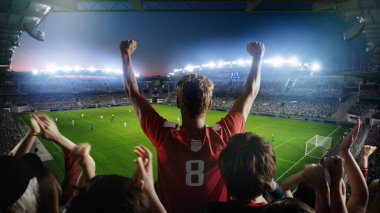 Futbol Şampiyonası Maçı sırasında Stadyumda Taraftarları için Tezahürat Çekimi. Takımlar oynar, Taraftarlar Çığlık atar, Zaferi Kutlar