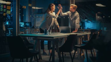 Başarılı Küçük İşletme Sahipleri Gece Ofisindeki Toplantıda İletişim kuruyor. Yetenekli Kadın ve Heyecanlı Adam Geleceğin Şirket Politikasını Tartışıyor