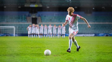 Büyük Lig Futbol Şampiyonası. Beyaz takımın forvet oyuncusu gol atmaya hazırlanıyor, takım arkadaşları arkada sıraya girsin. Canlı Spor