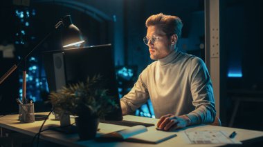 Geceleri Şirket ofisinde Masaüstü Bilgisayarı 'nda çalışan yakışıklı adam. Genç Uzman Analiz Raporları. Pazarlama Asistanı Bir Tüketici Geliştiriyor