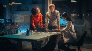 Çeşitli Genç Yöneticiler Ekibi Gece Ofiste Bir Toplantıda İş Tartışması Yapıyor. Başarılı İş Ortakları Pazarlama Kampanyası Hakkında Konuşuyor