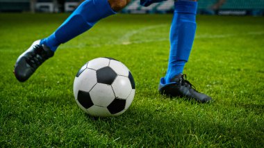 Bacak Tekmeleyen Futbol Topu 'nun yakın çekimi. Profesyonel Futbolcu Sert Güç, Puan Golü, Çimen Uçuşu ile Topa Vuruyor. Futbol mu?