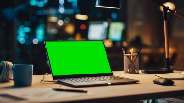 Yeşil Ekran Kromakey Mock Up ile Masanın Üzerinde Duran Laptop. Bilgisayarlı masa, kahve fincanı, kulaklık ve Yaratıcı Ofiste Not Defteri