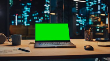 Yeşil Ekran Kromakey Mock Up ile Masanın Üzerinde Duran Laptop. Bilgisayarlı masa, kahve fincanı, kulaklık ve Yaratıcı Ofiste Not Defteri