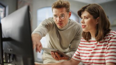 Bilgisayar ve Tablet Kullanarak Bir Çalışma Projesi Üzerinde İşbirliği Yapan İki Yaratıcı İş Birliği. Beyaz Erkek E-Ticaret Pazarlama Yöneticisi