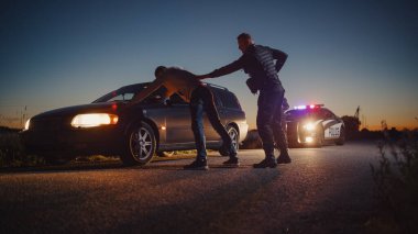 A Professional Middle Aged Policeman Performing a Pat-Down Search on a Fellon With his Hands on Car Hood. Documentary-like Shot of Procedure of clipart