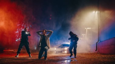 İki çok ırklı polis memuru bir şüpheliyi hedef alıyor. Polis, Aranan Suçlu 'yu korkutmak için silah kullanıyor. Suçlu Elleri Başa Koyuyor