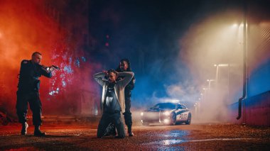 Profesyonel polis memuru şüpheliyi hedef alırken, siyahi kadın memur da onu kelepçeledi. Fellon Uyum içinde ellerini başının üstüne koyuyor. Polis Başarıyla