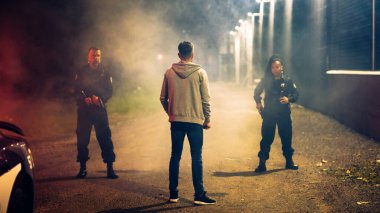 İki polis memuru şüpheliyi yakalayıp tutukladı. Law Tackle 'ın kahraman memurları ve Karanlık Şehir Caddesinde Tehlikeli Suçluları Durdurun. Polisler Tutukluyor