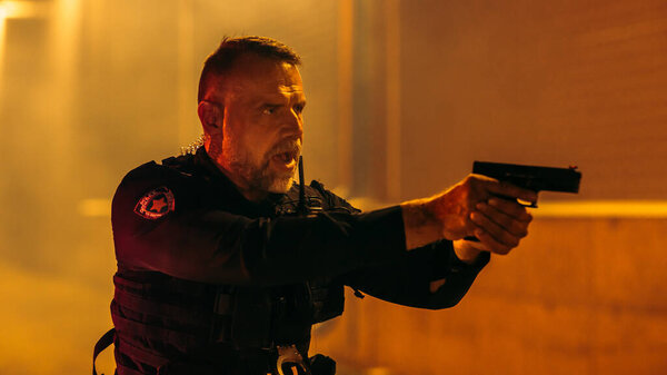 Портрет профессионального офицера полиции с фонариком, приказывающим преступнику прекратить сопротивление аресту. Не двигайся. Поднимите руки. Drop the