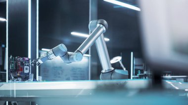 Fabrika Geliştirme Tesisinde Endüstriyel Programlanabilir Robotik Kol. Robot Kolu Prototip Mikroçipi Tutuyor. Makine ve Bilgisayarlı Teknoloji Ofisi