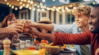 Bir Aile Kapanışı ve Çok Irklı Arkadaşlar Bir Bahçe Masası Yemeği 'nde Bir araya geliyorlar. Kadeh kaldıran ve kadeh kaldıran Yaşlılar ve Gençler