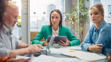 Toplantıda, Girişimci ve Uzman Ekibi Konferans Masası 'nda oturmuş istatistik ve grafikler, önderliğindeki sorunları çözme hakkında tartışıyorlar.