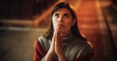 Dindar Hristiyan bir kadının dini inancı ve ruhaniliğinden bir rehber arayan, dua etmek için ellerini kavuşturan, dindar bir kadın portresi.