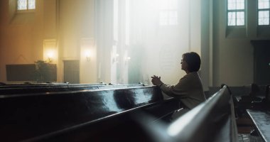 Dindar, yaşlı, dindar bir kadın kilisede dindar bir şekilde oturur, dua etmek için ellerini kavuşturur, dini inançlarından ve ruhaniliğinden rehberlik ister. Ruh