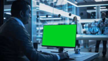 Yazılım Geliştirici Yeşil Ekran Mock Up Ekranı ile Bilgisayar üzerinde çalışıyor. Bilim Laboratuvarı, Mühendislik Araştırma Merkezi Uzmanlarla birlikte