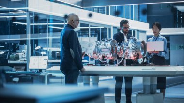Çeşitli Kültür Mühendisleri Ekibi Laptop Bilgisayarları, Analizler ve Gelecekçi Türbin Motorlarının Nasıl Çalıştığını Tartışır. Kıdemli Müdür Genç Bir Adamla Buluşuyor