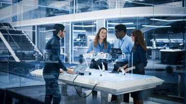 Endüstriyel Robot Mühendislerden oluşan çeşitli etnik gruplar bir robot köpekle bir masanın etrafında toplandı. Bilim adamları araştırmak için dizüstü bilgisayar kullanıyor