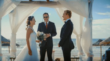 Güzel Gelin ve Damat Okyanus Kıyısındaki Bir Sahilde Açık Hava Düğün Töreni sırasında. Romantik bir çiftin evlenmesi, öpüşmesi ve öpüşmesi için mükemmel bir yer.