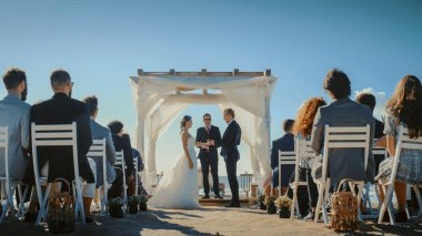 Güzel Gelin ve Damat Ocean Beach 'te bir açık hava düğün seremonisi sırasında. Romantik Çiftler Evlenip Yüzüklerini Değiştirmek İçin Mükemmel Bir Yer