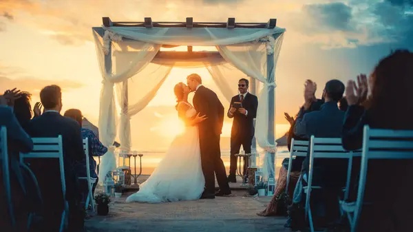 stock image Beautiful Bride and Groom During an Outdoors Wedding Ceremony on an Ocean Beach at Sunset. Perfect Venue for Romantic Couple to Get Married, Exchange