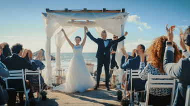 Güzel Gelin ve Damat Ocean Beach 'te bir açık hava düğün seremonisi sırasında. Romantik Çiftler Evlenip Yüzüklerini Değiştirmek İçin Mükemmel Bir Yer