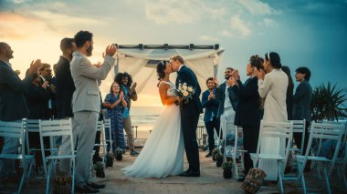 Güzel Gelin ve Damat, Sunset 'te Okyanus Kıyısındaki Açık Hava Düğünü' nü Kutluyor. En İyi Çok Irklı Arkadaşlara sahip Mükemmel Evlilik Yeri