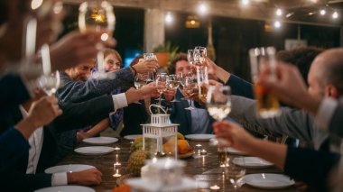 Bir restoranda kutlama yapan etnik çeşitlilikte küçük bir arkadaş grubuyla büyük bir akşam yemeği partisi. Güzel Mutlu Ev Sahipleri Kadeh kaldırmayı ve Şarap Artırmayı Öneriyor