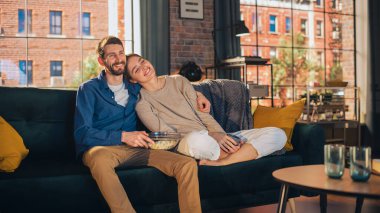 Evlerinde vakit geçiren genç bir çiftin portresi, bir koltukta oturan, apartmandaki heyecanlı TV programını izlerken kız arkadaşını kucaklayan bir adam. Erkek ve