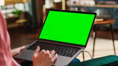 Genç Yetişkin Kadın Yeşil Ekran Mock Up Ekranı ile Laptop Bilgisayarda Ev Apartmanından Çalışıyor. Trackpad ve Tarama Kullanarak Yaratıcı Kadın