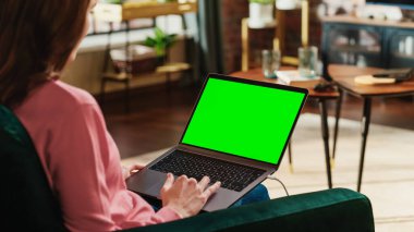 Genç Yetişkin Kadın Yeşil Ekran Mock Up Ekranı ile Laptop Bilgisayarda Ev Apartmanından Çalışıyor. Trackpad ve Tarama Kullanarak Yaratıcı Kadın