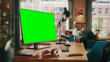 Masaüstü Bilgisayarı 'nda Mock Up Green Screen Ekranı Samimi Oturma Odasında Masanın Üzerinde Duruyor. Arka planda Modern Parlak Ofis Stüdyosunda