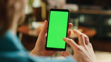 Adam Kaydırma Kaydırma Kaynağı ve Akıllı Telefon 'da Yeşil Ekran Mock Up Ekranı ile Çift Tıklama. Erkek Evde Dinleniyor, Sosyal Medya Denetiliyor