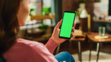 Yeşil Ekran Mock Up Ekranı ile Kadın El Tıklaması ve Akıllı Telefondan Kaydırma Kaynağı. Kadın Evde Dinleniyor, Sosyal Medya Denetiliyor