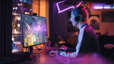 Profesyonel eSports Female Gamer, Evdeki Güçlü Kişisel Bilgisayarında Bir Çok Eylem ve Eğlenceyle RPG Strateji Video Oyunu oynuyor. Sanal Oyun