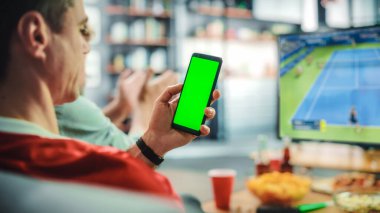 Evde: Tenis Hayranı Yeşil Ekran Kroma Anahtar Zeka Telefonu Tutuyor, TV 'de Arkadaşlar Yoğun Maç İzliyor, Favori Sporcu Kadın İçin Tezahürat Kazanacak