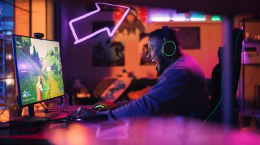 Evde Oyun: Afrikalı Amerikalı Oyuncu Kişisel Bilgisayarda Online Video Oyunu Oynuyor. Tarz sahibi Erkek Oyuncu Ekranı Gösteren 3B Nişancının keyfini çıkarıyor